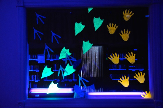 We painted these neon paw prints on a window in the black light room.