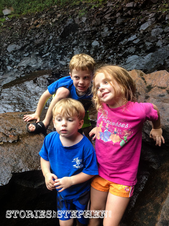 My kids on the wet rocks underneath Fall Creek Falls.