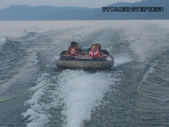 Sam, Julie Beth, Will & Kalon all riding the tube together behind the ski boat.