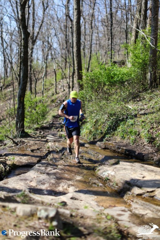 Here I am at 15.5 miles running across the top of a waterfall as I finish the McKay Hollow Madness 25K Trail Race.